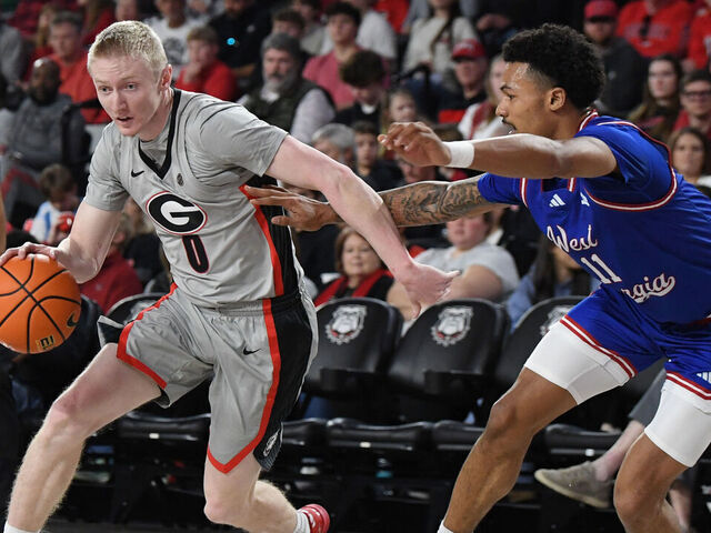 ATHENS, GA - DECEMBER 22: Guard Blue Cain #0 of the Georgia Bulldogs drives to the basket as forward Kolten Griffin #11 of the West Georgia Wolves defends during the college basketball game between the West Georgia Wolves and the Georgia Bulldogs on December 22, 2025, at Stegeman Coliseum in Athens, GA.