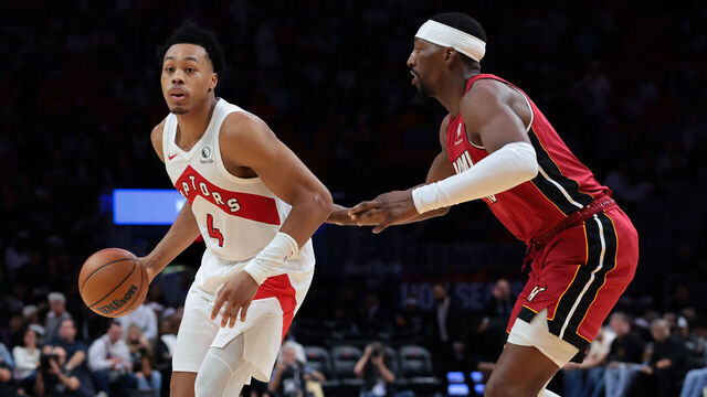 MIAMI, FLORIDA - DECEMBER 23: Scottie Barnes #4 of the Toronto Raptors dribbles the basketball as Bam Adebayo #13 of the Miami Heat defends during the second half at Kaseya Center on December 23, 2025 in Miami, Florida.