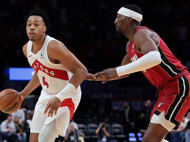 MIAMI, FLORIDA - DECEMBER 23: Scottie Barnes #4 of the Toronto Raptors dribbles the basketball as Bam Adebayo #13 of the Miami Heat defends during the second half at Kaseya Center on December 23, 2025 in Miami, Florida.