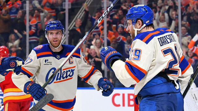 EDMONTON, CANADA - DECEMBER 23: Leon Draisaitl #29, Connor McDavid #97 and Zach Hyman #18 of the Edmonton Oilers celebrate a third-period goal against the Calgary Flames during the game at Rogers Place on December 23, 2025, in Edmonton, Alberta, Canada.
