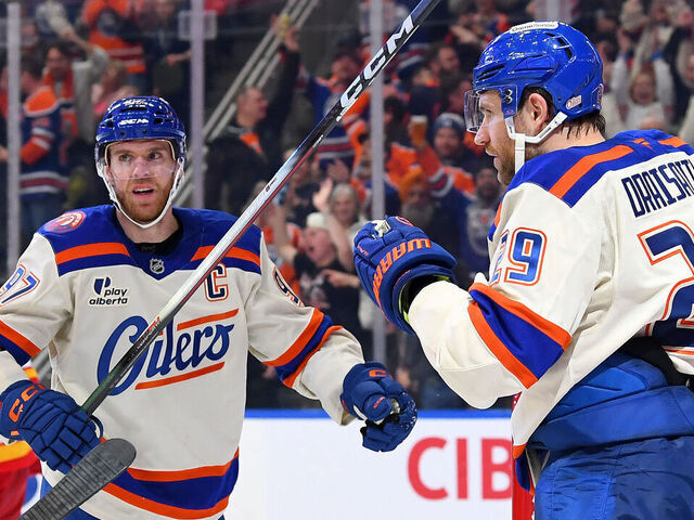 EDMONTON, CANADA - DECEMBER 23: Leon Draisaitl #29, Connor McDavid #97 and Zach Hyman #18 of the Edmonton Oilers celebrate a third-period goal against the Calgary Flames during the game at Rogers Place on December 23, 2025, in Edmonton, Alberta, Canada.