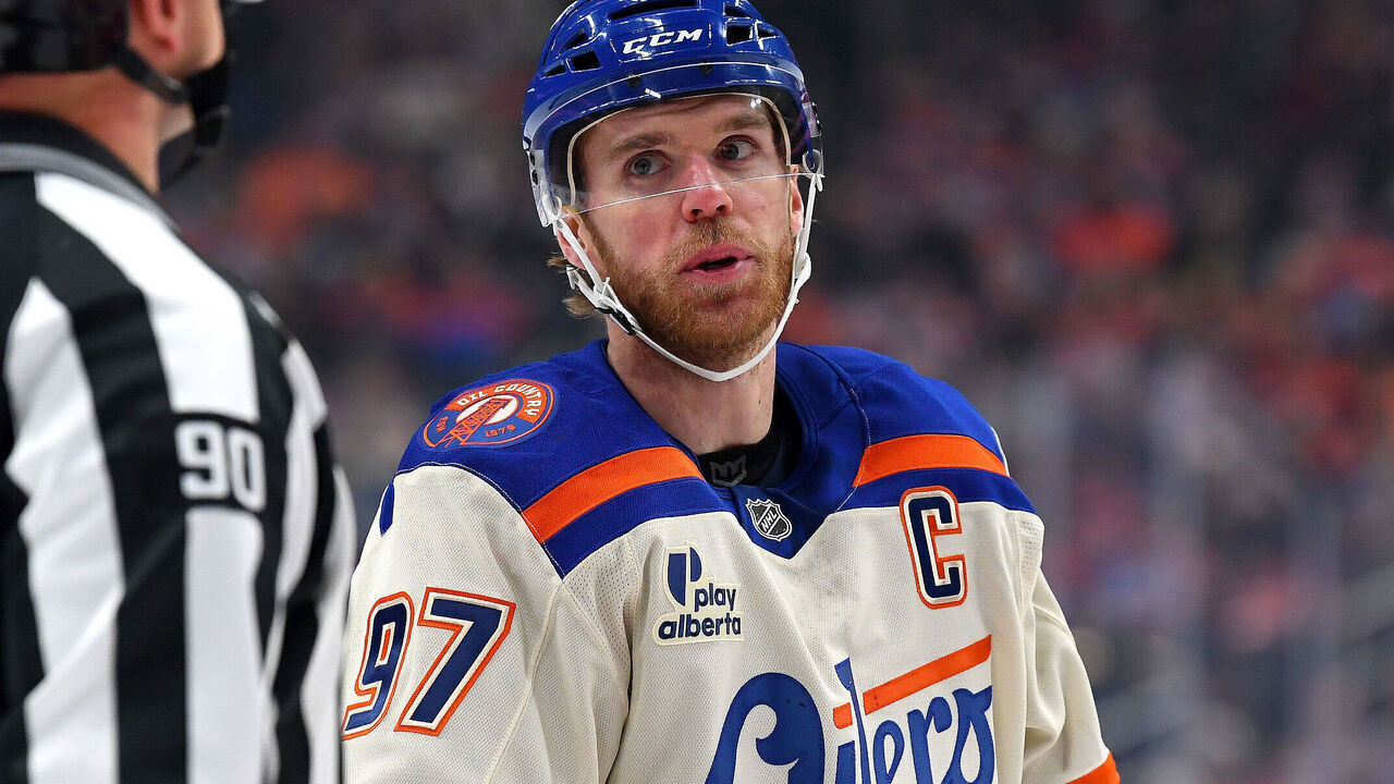 EDMONTON, CANADA - DECEMBER 23: Connor McDavid #97 of the Edmonton Oilers has a conversation with linesperson Travis Toomey #90 during a stoppage in play in the first period of the game against the Calgary Flames at Rogers Place on December 23, 2025, in Edmonton, Alberta, Canada.