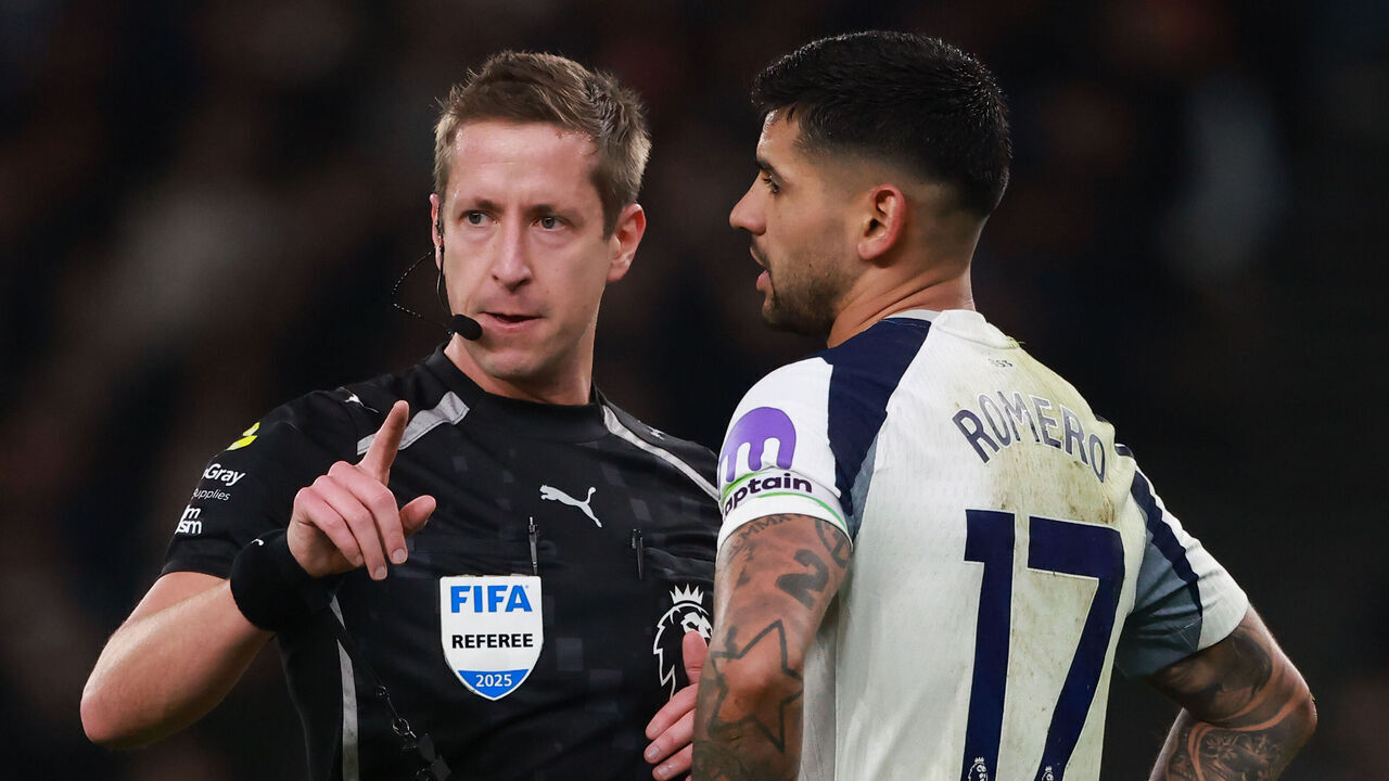 LONDON, ENGLAND - DECEMBER 20: Referee John Brooks speaks with Cristian Romero of Tottenham Hotspur during the Premier League match between Tottenham Hotspur and Liverpool at Tottenham Hotspur Stadium on December 20, 2025 in London, England.