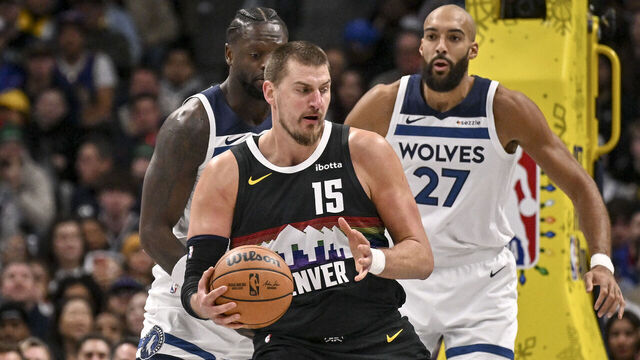 DENVER , CO - DECEMBER 25: Nikola Jokic (15) of the Denver Nuggets works against Julius Randle (30) and Rudy Gobert (27) of the Minnesota Timberwolves during the first quarter at Ball Arena in Denver, Colorado on Thursday, December 25, 2025.
