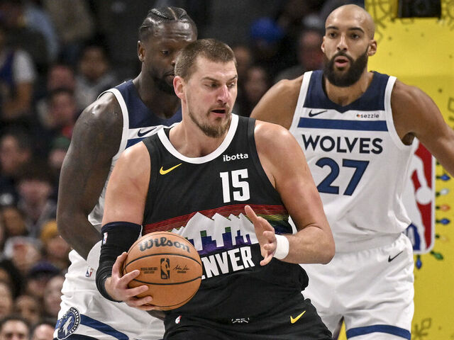 DENVER , CO - DECEMBER 25: Nikola Jokic (15) of the Denver Nuggets works against Julius Randle (30) and Rudy Gobert (27) of the Minnesota Timberwolves during the first quarter at Ball Arena in Denver, Colorado on Thursday, December 25, 2025.