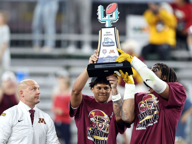 PHOENIX, ARIZONA - DECEMBER 26: Jalen Smith #8 (C) and Anthony Smith #0 of the Minnesota Golden Gophers hold the championship trophy alongside head coach P. J. Fleck after defeating the New Mexico Lobos 20-17 in overtime of the 2025 Rate Bowl at Chase Field on December 26, 2025 in Phoenix, Arizona.