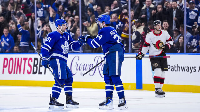 TORONTO, CANADA - DECEMBER 27: Auston Matthews #34 congratulates John Tavares #91 of the Toronto Maple Leafs on an empty net goal against the Ottawa Senators during the third period at the Scotiabank Arena on December 27, 2025 in Toronto, Ontario, Canada.