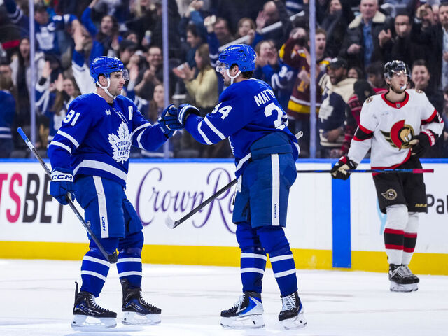 TORONTO, CANADA - DECEMBER 27: Auston Matthews #34 congratulates John Tavares #91 of the Toronto Maple Leafs on an empty net goal against the Ottawa Senators during the third period at the Scotiabank Arena on December 27, 2025 in Toronto, Ontario, Canada.