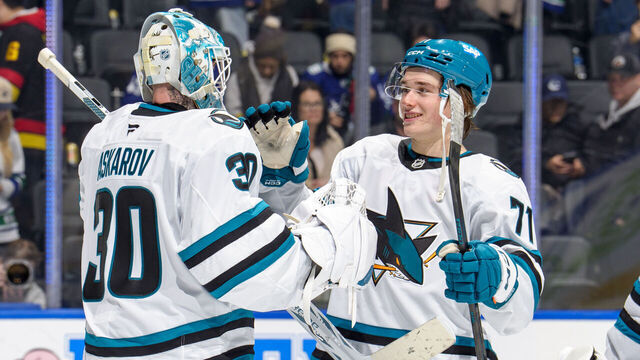 VANCOUVER, CANADA - DECEMBER 27: Yaroslav Askarov #30 celebrates with Macklin Celebrini #71 of the San Jose Sharks after their win against the Vancouver Canucks at Rogers Arena on December 27, 2025 in Vancouver, British Columbia, Canada. Sharks won 6-3.