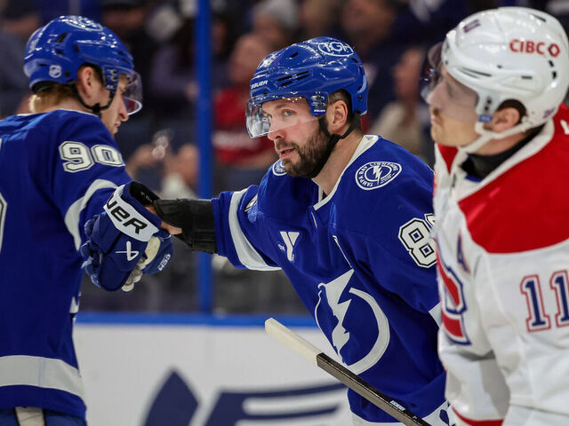 TAMPA, FLORIDA - DECEMBER 28: Nikita Kucherov #86 of the Tampa Bay Lightning celebrates his goal with teammate J.J. Moser #90 as Brendan Gallagher #11 of the Montréal Canadiens reacts during the second period at the Benchmark International Arena on December 28, 2025 in Tampa, Florida.