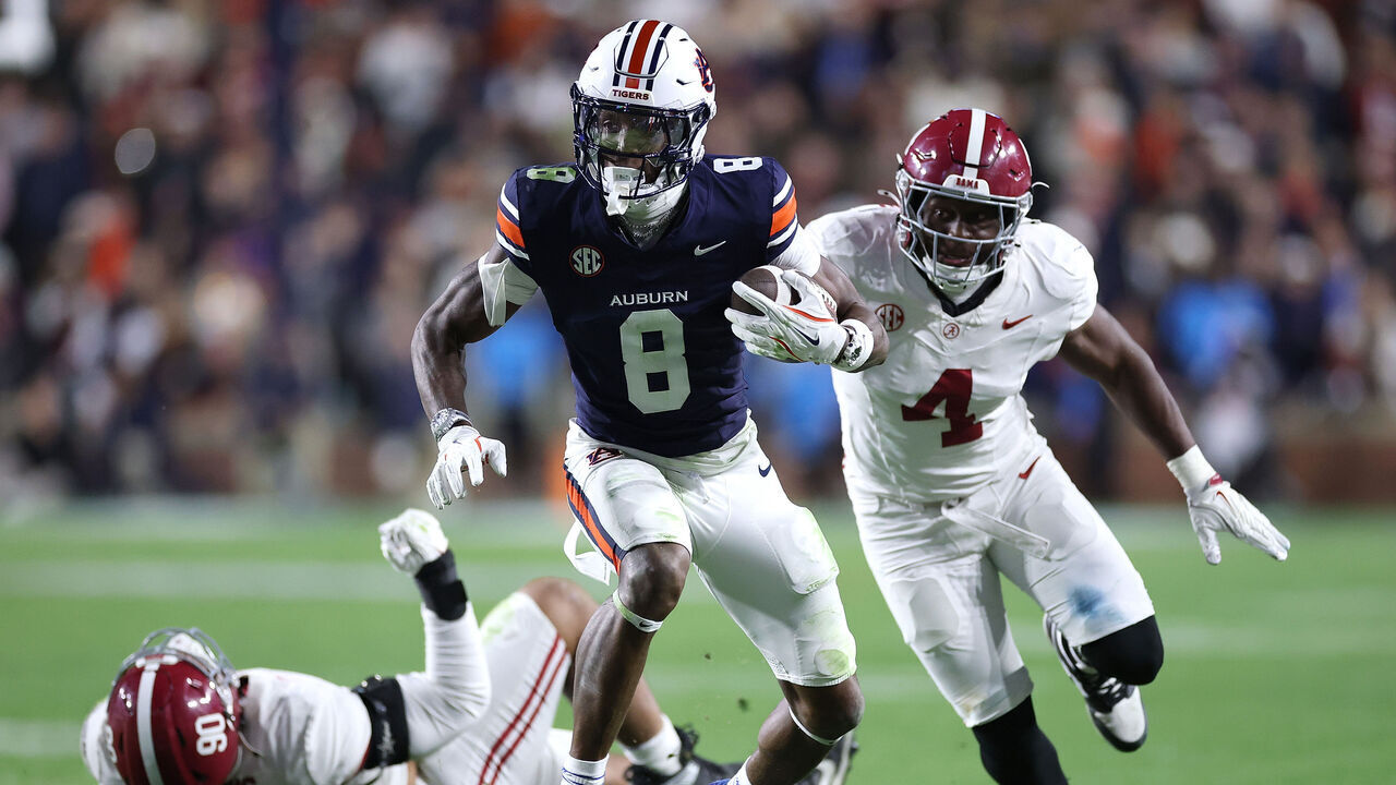 AUBURN, ALABAMA - NOVEMBER 29: Cam Coleman #8 of the Auburn Tigers runs with the ball past Qua Russaw #4 of the Alabama Crimson Tide during the fourth quarter at Jordan-Hare Stadium on November 29, 2025 in Auburn, Alabama.