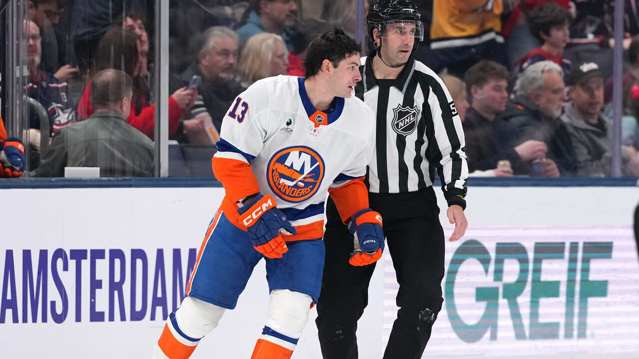 COLUMBUS, OHIO - DECEMBER 28: Linesman Andrew Smith #51 skates Mathew Barzal #13 of the New York Islanders to the penalty box after being called for slashing on Mason Marchment #17 of the Columbus Blue Jackets during the second period at Nationwide Arena on December 28, 2025 in Columbus, Ohio.