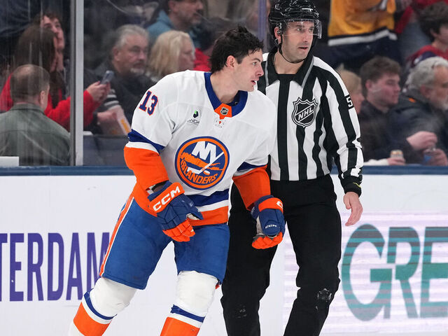 COLUMBUS, OHIO - DECEMBER 28: Linesman Andrew Smith #51 skates Mathew Barzal #13 of the New York Islanders to the penalty box after being called for slashing on Mason Marchment #17 of the Columbus Blue Jackets during the second period at Nationwide Arena on December 28, 2025 in Columbus, Ohio.