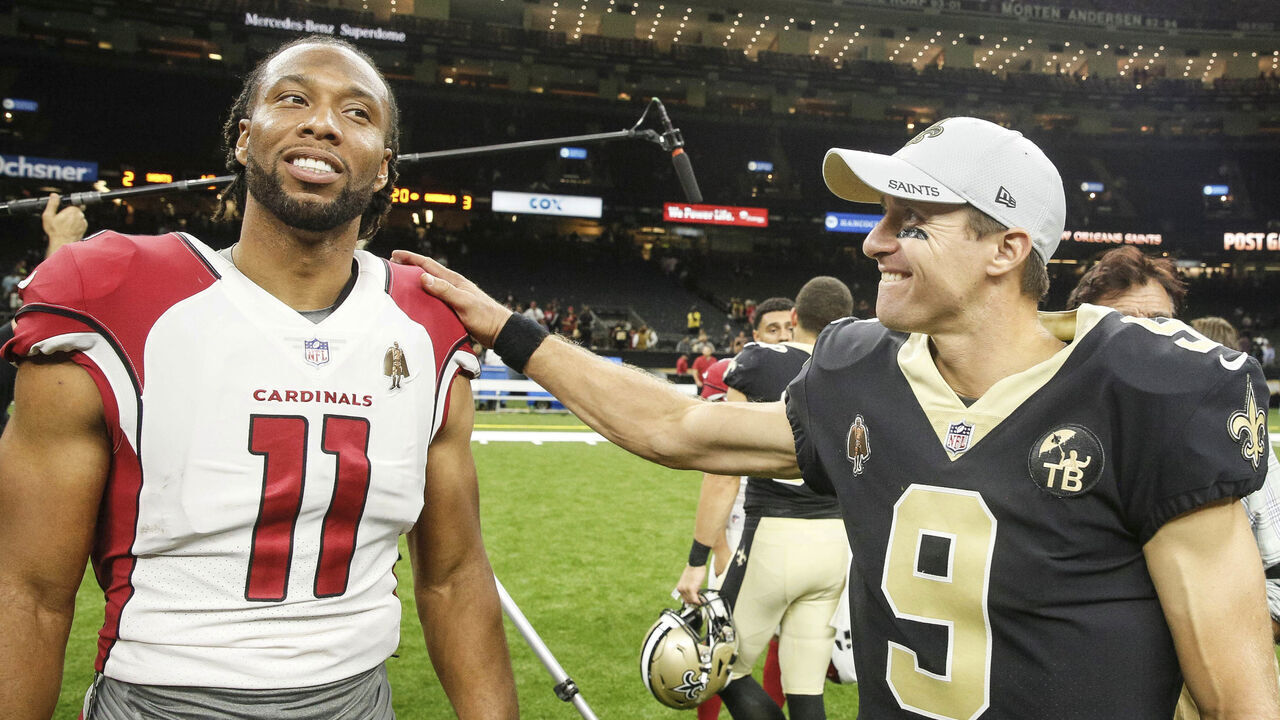 NEW ORLEANS, LOUSIANA - AUGUST 17: New Orleans Saints quarterback Drew Brees (9) talks with Arizona Cardinals wide receiver Larry Fitzgerald (11) following a preseason game at the Mercedes-Benz Superdome on August 17, 2018 in New Orleans, Louisiana.