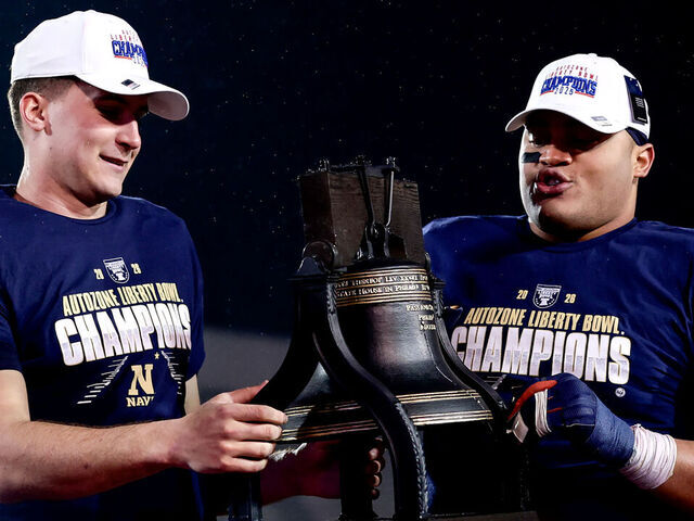 MEMPHIS, TN - JANUARY 02: Navy Midshipmen quarterback Blake Horvath (L) and nose guard Landon Robinson (R) hold the trophy after winning the AutoZone Liberty Bowl game, between the Cincinnati Bearcats and the Navy Midshipmen on January 2, 2026, at Simmons Bank Liberty Stadium in Memphis, Tennessee.