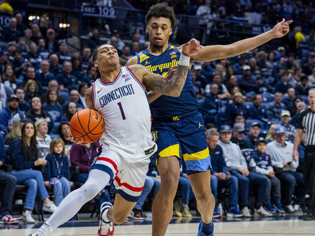 STORRS, CONNECTICUT - JANUARY 04: Solo Ball #1 of the Connecticut Huskies is defended by Caedin Hamilton #18 of the Marquette Golden Eagles during the first half of an NCAA men's basketball game at Harry A. Gampel Pavilion on January 04, 2026 in Storrs, Connecticut.