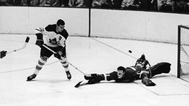 Canadian professional ice hockey player Bob Pulford of the Toronto Maple Leafs watches as his shot on goal flies over the head of goalie Terry Sawchuk of the Detroit Red Wings during the Third Period of a game, Detroit, 1963. The shot missed and Detroit won 3 - 2.