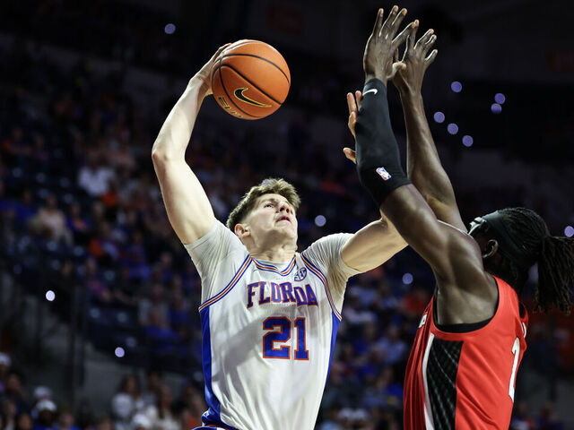 GAINESVILLE, FLORIDA - JANUARY 06: Alex Condon #21 of the Florida Gators dunks the ball against Somto Cyril #2 of the Georgia Bulldogs during the first half of a game at the Stephen C. O'Connell Center on January 06, 2026 in Gainesville, Florida.