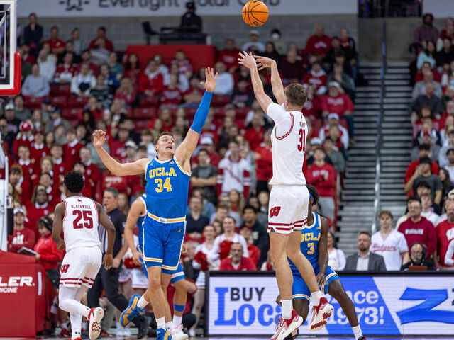 Nolan Winter #31 of the Wisconsin Badgers shoots a three-pointer over Tyler Bilodeau #34 of the UCLA Bruins at the Kohl Center in Madison, Wisconsin, on January 6, 2026.