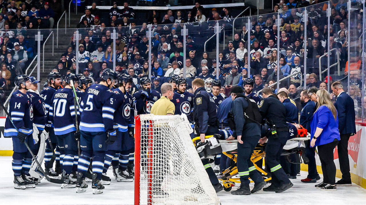 WINNIPEG, CANADA - JANUARY 6: Winnipeg Jets players gather around teammate Haydn Fleury #24 as he's taken off the ice on a stretcher following a collision against the boards during first period action against the Vegas Golden Knights at the Canada Life Centre on January 6, 2026 in Winnipeg, Manitoba, Canada.