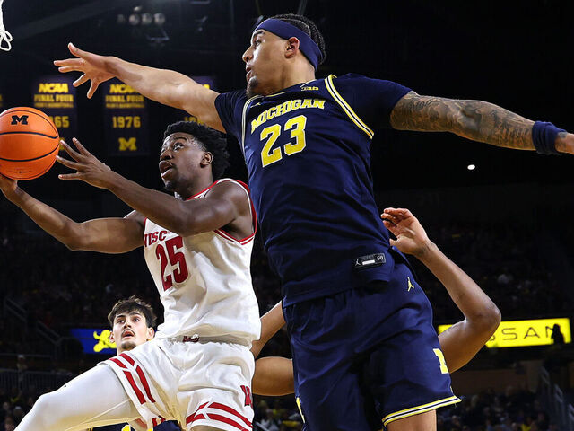 ANN ARBOR, MICHIGAN - JANUARY 10: John Blackwell #25 of the Wisconsin Badgers drives to the basket against Yaxel Lendeborg #23 of the Michigan Wolverines during the second half at Crisler Arena on January 10, 2026 in Ann Arbor, Michigan.