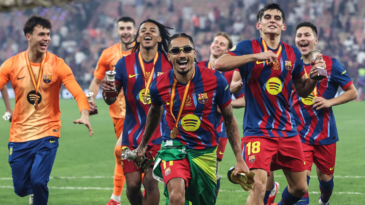 Barcelona's Brazilian forward #11 Raphinha celebrates with teammates after winning the Spanish Super Cup final football match between FC Barcelona and Real Madrid at the King Abdullah Stadium in Jeddah on January 11, 2026.