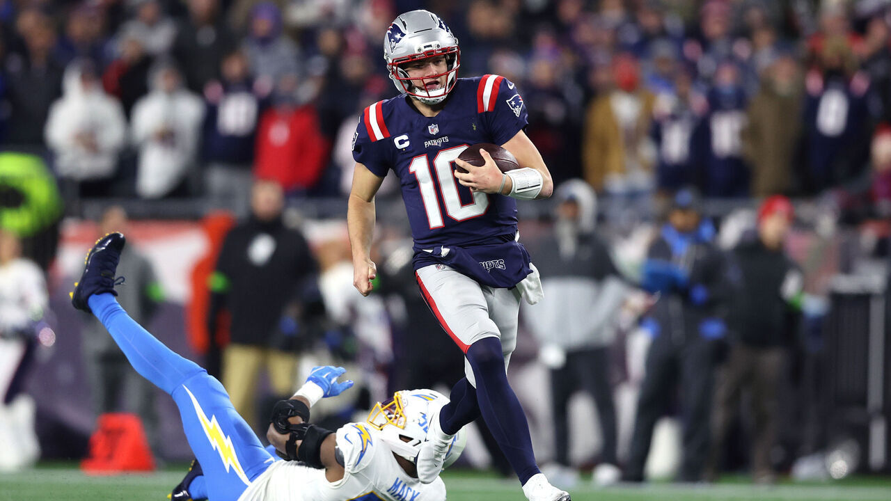 FOXBOROUGH, MASSACHUSETTS - JANUARY 11: Drake Maye #10 of the New England Patriots avoids a tackle Khalil Mack #52 of the Los Angeles Chargers during the second quarter of the AFC Wild Card Playoff game at Gillette Stadium on January 11, 2026 in Foxborough, Massachusetts.