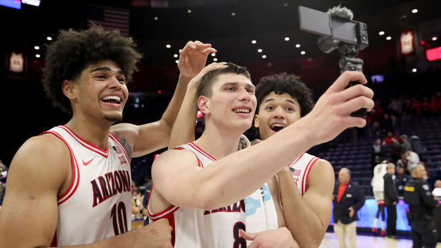 TUCSON, AZ - JANUARY 07: Arizona Wildcats forward Koa Peat (10), forward Ivan Kharchenkov (8) and guard Brayden Burries (5) record a post to social media after a men's basketball game between the Kansas State Wildcats and the Arizona Wildcats on January 7, 2026, at McKale Center in Tucson, AZ.