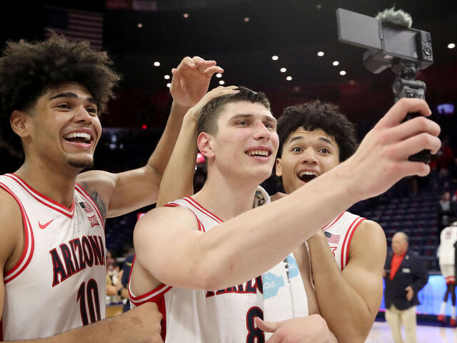 TUCSON, AZ - JANUARY 07: Arizona Wildcats forward Koa Peat (10), forward Ivan Kharchenkov (8) and guard Brayden Burries (5) record a post to social media after a men's basketball game between the Kansas State Wildcats and the Arizona Wildcats on January 7, 2026, at McKale Center in Tucson, AZ.