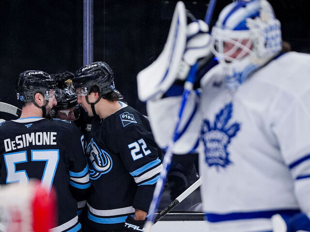 SALT LAKE CITY, UTAH - JANUARY 13: Nick DeSimone #57, Dylan Guenther #11, and Jack McBain #22 of the Utah Mammoth celebrate a goal during the second period at Delta Center on January 13, 2025 in Salt Lake City, Utah.