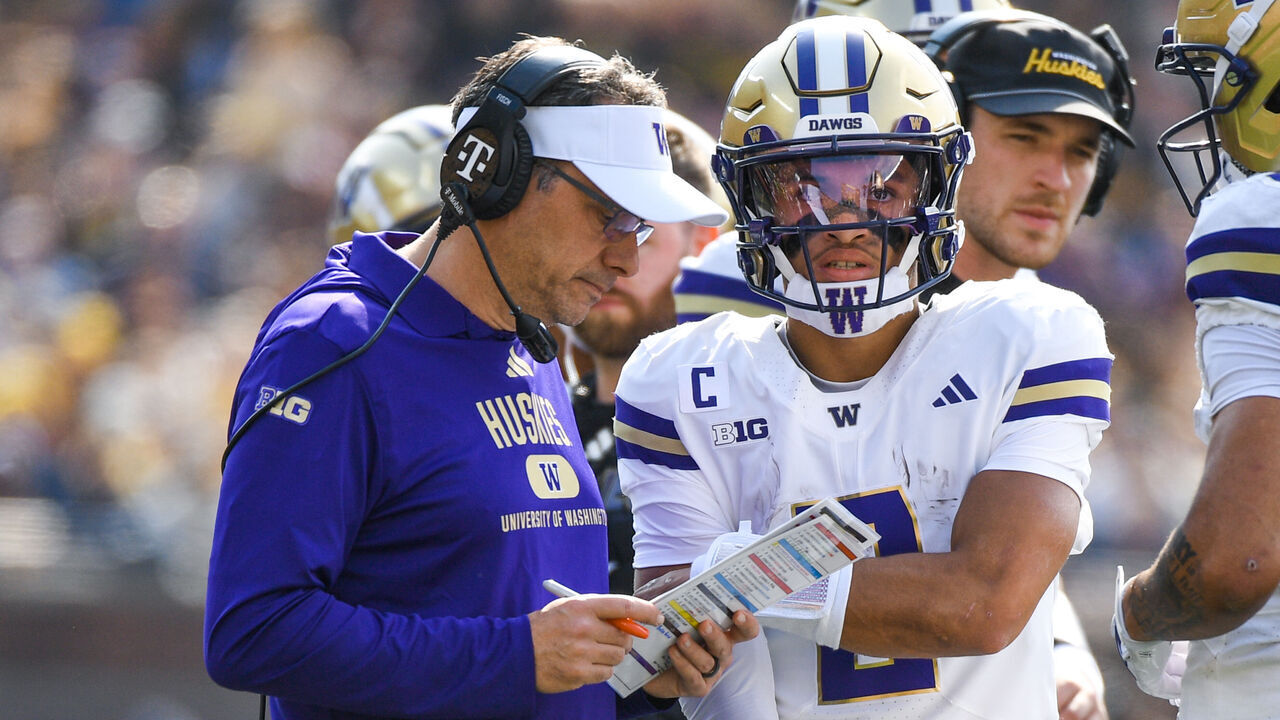 ANN ARBOR, MICHIGAN - OCTOBER 18: Head Football Coach Jedd Fisch and Demond Williams Jr. #2 of the Washington Huskies go over a play on the sideline during the first half of a college football game against the Michigan Wolverines at Michigan Stadium on October 18, 2025 in Ann Arbor, Michigan.