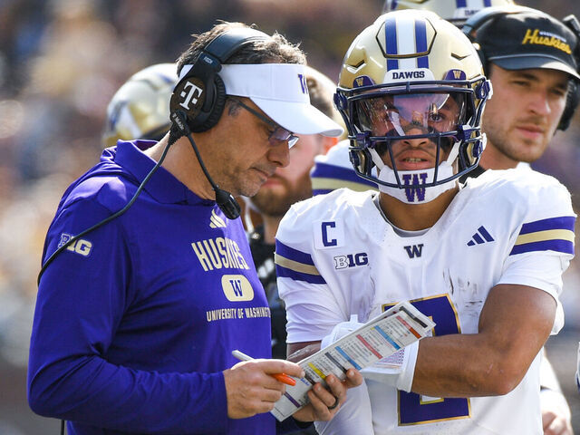 ANN ARBOR, MICHIGAN - OCTOBER 18: Head Football Coach Jedd Fisch and Demond Williams Jr. #2 of the Washington Huskies go over a play on the sideline during the first half of a college football game against the Michigan Wolverines at Michigan Stadium on October 18, 2025 in Ann Arbor, Michigan.