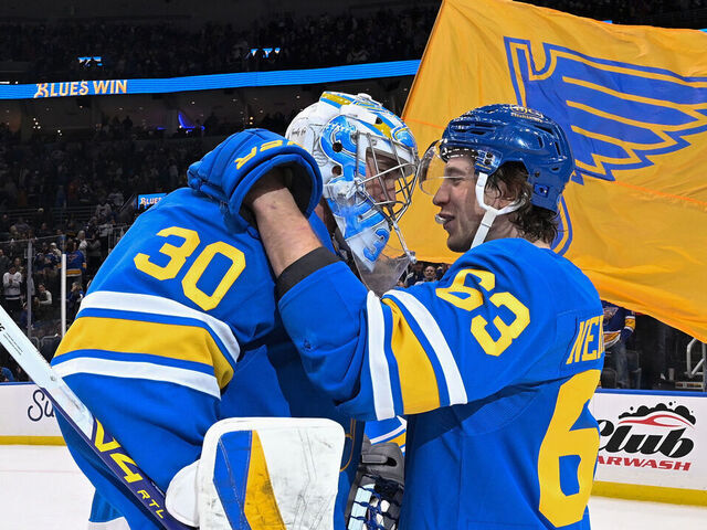 ST. LOUIS, MO - JANUARY 16: Jake Neighbours #63 congratulates Joel Hofer #30 of the St. Louis Blues after the shootout victory over the Tampa Bay Lightning on January 16, 2026 at the Enterprise Center in St. Louis, Missouri.