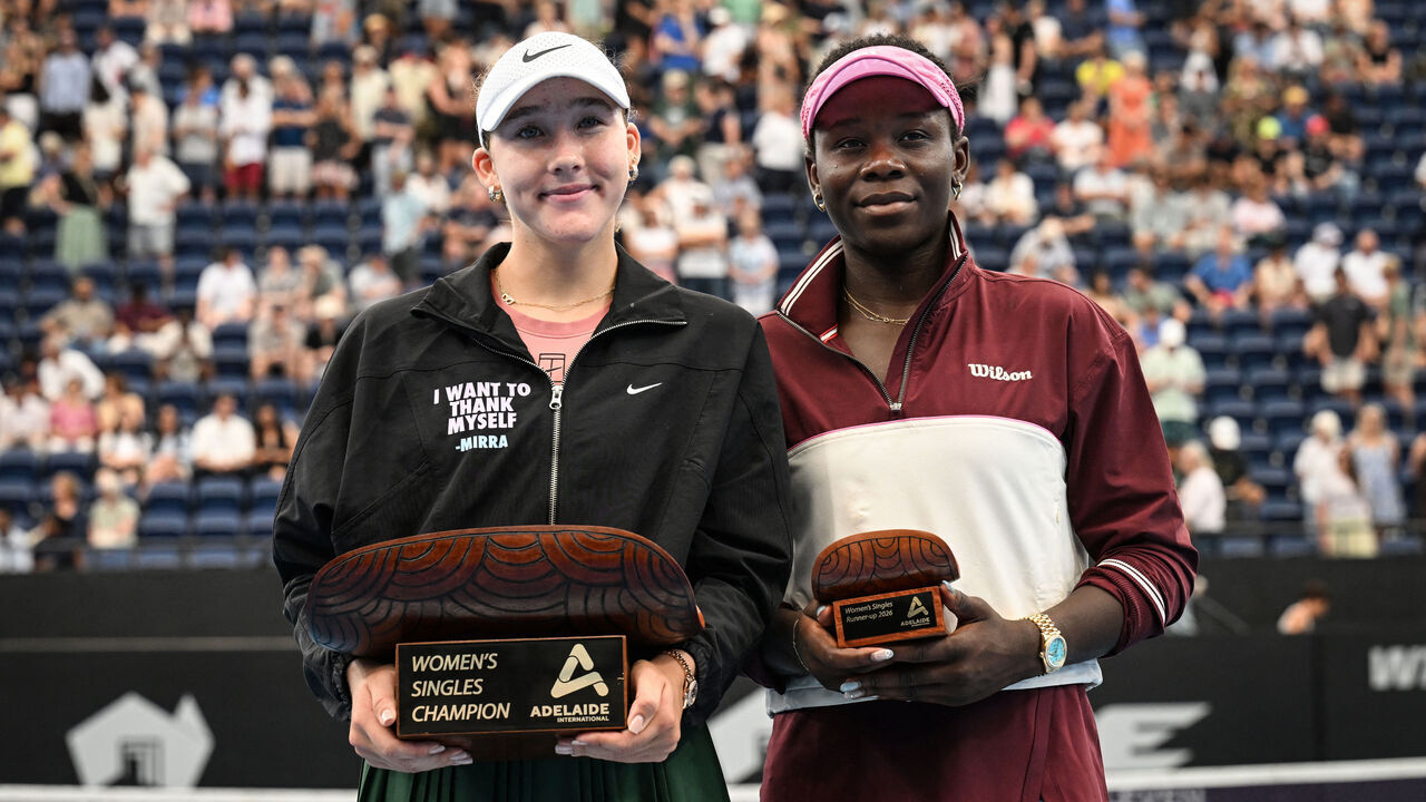 Russia's Mirra Andreeva (L) and Canada's Victoria Mboko pose with their trophies after their women's singles final match at the Adelaide International tennis tournament in Adelaide on January 17, 2026. / --IMAGE RESTRICTED TO EDITORIAL USE - STRICTLY NO COMMERCIAL USE--
