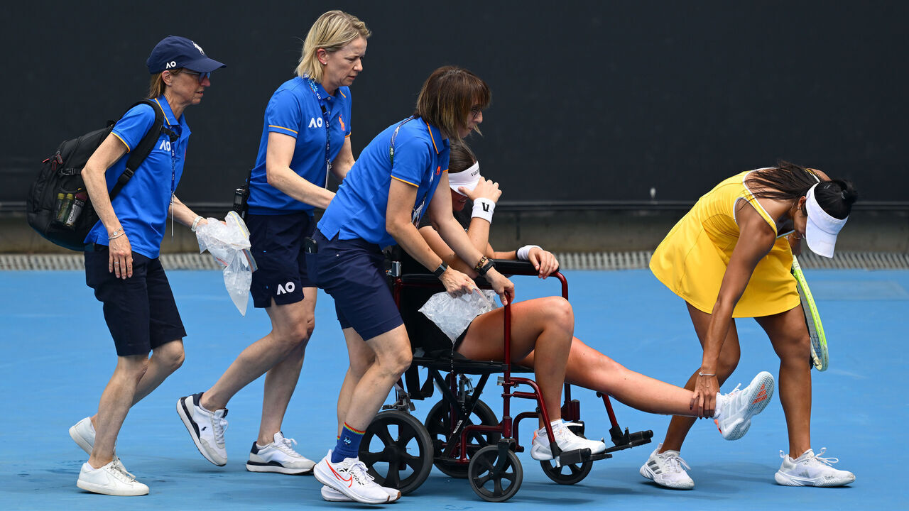 MELBOURNE, AUSTRALIA - JANUARY 19: Priscilla Hon (R) of Australia helps Marina Stakusic of Canada leaving the court on a wheelchair after retiring due to injury in the Women's Singles First Round during day two of the 2026 Australian Open at Melbourne Park on January 19, 2026 in Melbourne, Australia.
