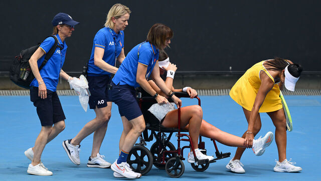 MELBOURNE, AUSTRALIA - JANUARY 19: Priscilla Hon (R) of Australia helps Marina Stakusic of Canada leaving the court on a wheelchair after retiring due to injury in the Women's Singles First Round during day two of the 2026 Australian Open at Melbourne Park on January 19, 2026 in Melbourne, Australia.