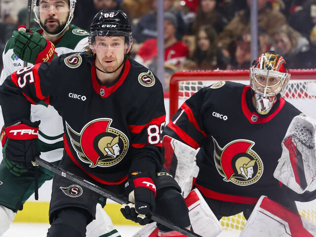 OTTAWA, ON - FEBRUARY 01: Ottawa Senators Defenceman Jake Sanderson (85) battles Minnesota Wild Center Devin Shore (19) in front of Ottawa Senators Goalie Leevi Merilainen (1) during second period National Hockey League action between the Minnesota Wild and Ottawa Senators on February 1, 2025, at Canadian Tire Centre in Ottawa, ON, Canada.