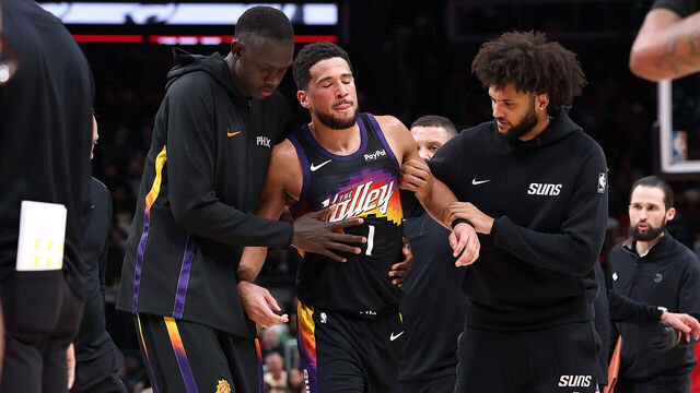 ATLANTA, GEORGIA - JANUARY 23: Devin Booker #1 of the Phoenix Suns is helped off the court after an injury against the Atlanta Hawks during the third quarter at State Farm Arena on January 23, 2026 in Atlanta, Georgia.