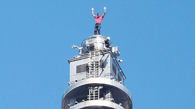 TOPSHOT - US rock climber Alex Honnold raises his arms from the top of the Taipei 101 building after he successfully free soloed the landmark skyscraper without ropes or safety gear in Taipei on January 25, 2026.