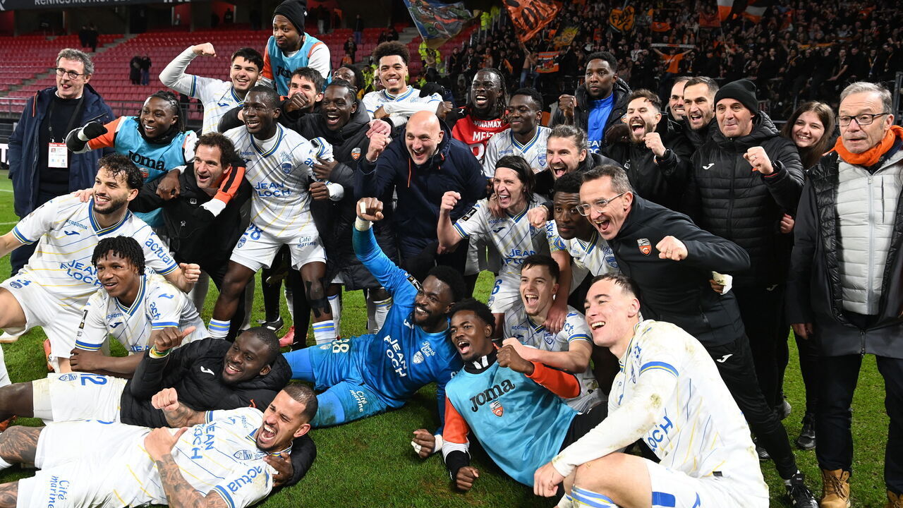 Lorient's French head coach Olivier Pantaloni (C) celebrates his team's victory with his players and staff at the end of the French L1 football match between Stade Rennais FC and FC Lorient at the Roazhon Park stadium in Rennes, western France, on January 24, 2026.