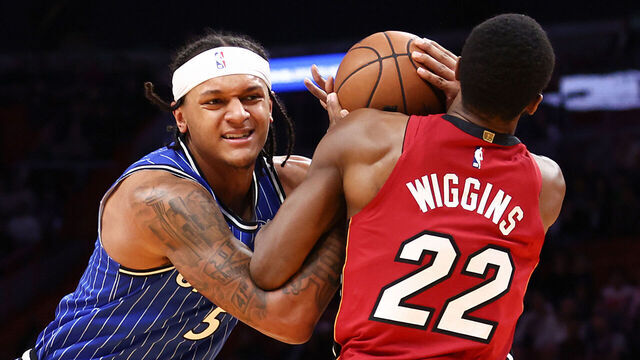 MIAMI, FLORIDA - JANUARY 28: Paolo Banchero #5 of the Orlando Magic drives against Andrew Wiggins #22 of the Miami Heat during the first quarter at Kaseya Center on January 28, 2026 in Miami, Florida.