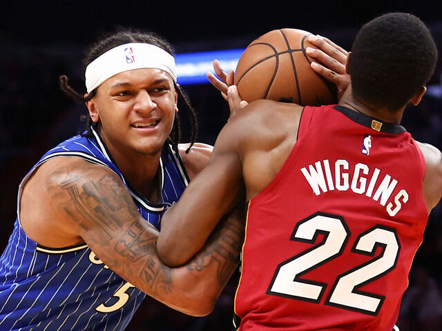 MIAMI, FLORIDA - JANUARY 28: Paolo Banchero #5 of the Orlando Magic drives against Andrew Wiggins #22 of the Miami Heat during the first quarter at Kaseya Center on January 28, 2026 in Miami, Florida.