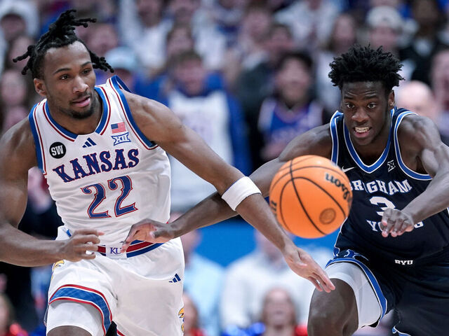 LAWRENCE, KANSAS - JANUARY 31: Darryn Peterson #22 of the Kansas Jayhawks and forward AJ Dybantsa #3 of the BYU Cougars chase down a loose ball in the first half at Allen Fieldhouse on January 31, 2026 in Lawrence, Kansas.