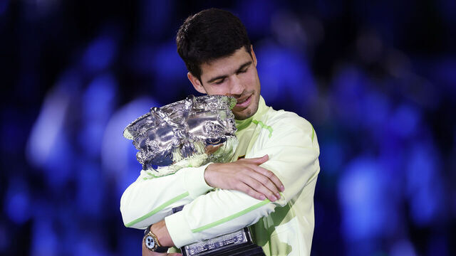MELBOURNE, AUSTRALIA - FEBRUARY 01: Carlos Alcaraz of Spain hugs the Norman Brookes Challenge Cup at the presentation ceremony after his victory in the Men's Singles Final against Novak Djokovic of Serbia during day 15 of the 2026 Australian Open at Melbourne Park on February 01, 2026 in Melbourne, Australia.