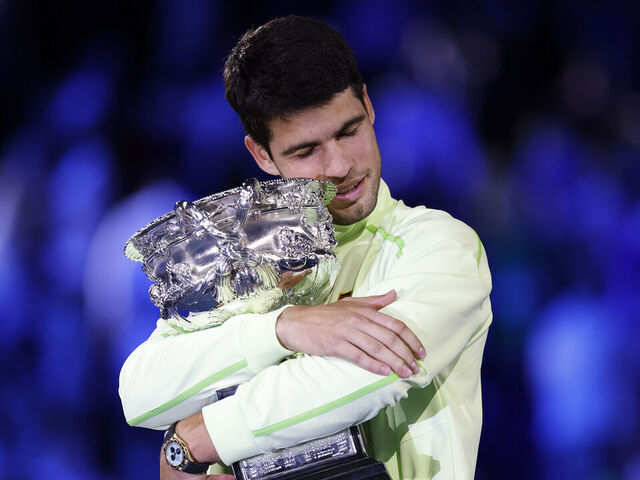 MELBOURNE, AUSTRALIA - FEBRUARY 01: Carlos Alcaraz of Spain hugs the Norman Brookes Challenge Cup at the presentation ceremony after his victory in the Men's Singles Final against Novak Djokovic of Serbia during day 15 of the 2026 Australian Open at Melbourne Park on February 01, 2026 in Melbourne, Australia.