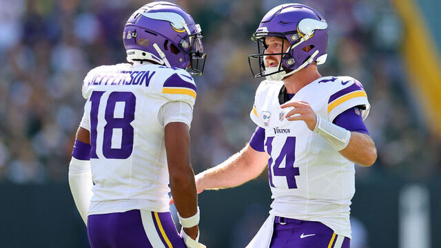 GREEN BAY, WISCONSIN - SEPTEMBER 29: Justin Jefferson #18 and Sam Darnold #14 of the Minnesota Vikings celebrate a touchdown against the Green Bay Packers during the first quarter of the game at Lambeau Field on September 29, 2024 in Green Bay, Wisconsin.