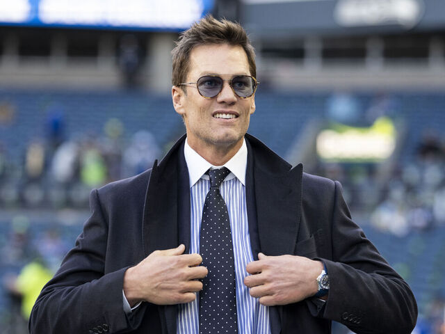 SEATTLE, WASHINGTON - JANUARY 25: Fox Sports commentator and former NFL quarterback Tom Brady reacts as he walks on to the field prior to an NFC Championship NFL football game between the Los Angeles Rams and Seattle Seahawks at Lumen Field on January 25, 2026 in Seattle, Washington.