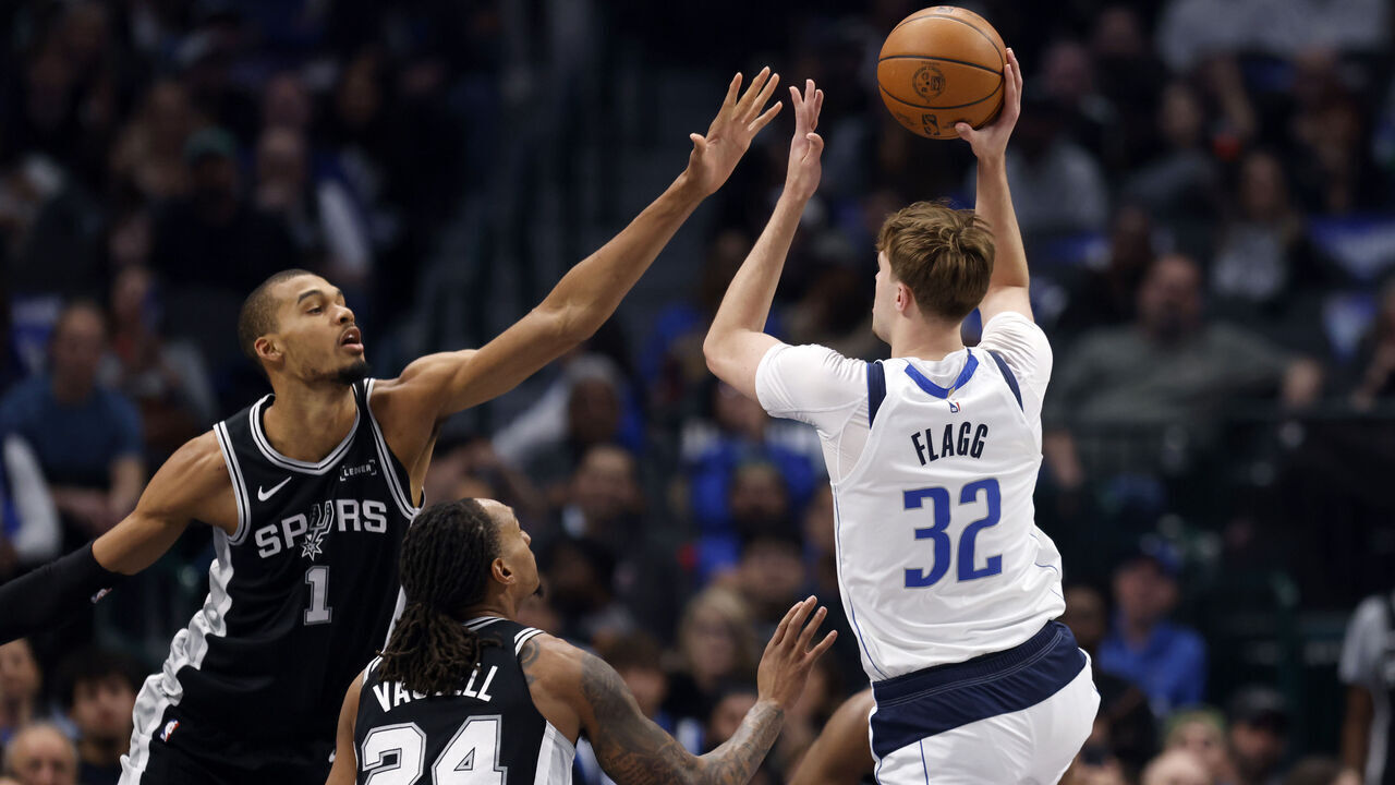 DALLAS, TEXAS - FEBRUARY 5: Cooper Flagg #32 of the Dallas Mavericks shoots the ball against Victor Wembanyama #1 and Devin Vassell #24 of the San Antonio Spurs during the first half at American Airlines Center on February 5, 2026 in Dallas, Texas.