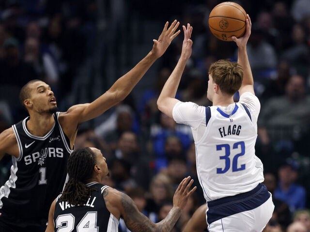 DALLAS, TEXAS - FEBRUARY 5: Cooper Flagg #32 of the Dallas Mavericks shoots the ball against Victor Wembanyama #1 and Devin Vassell #24 of the San Antonio Spurs during the first half at American Airlines Center on February 5, 2026 in Dallas, Texas.