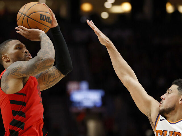 PORTLAND, OREGON - OCTOBER 21: Damian Lillard #0 of the Portland Trail Blazers shoots against Devin Booker #1 of the Phoenix Suns at Moda Center on October 21, 2022 in Portland, Oregon.